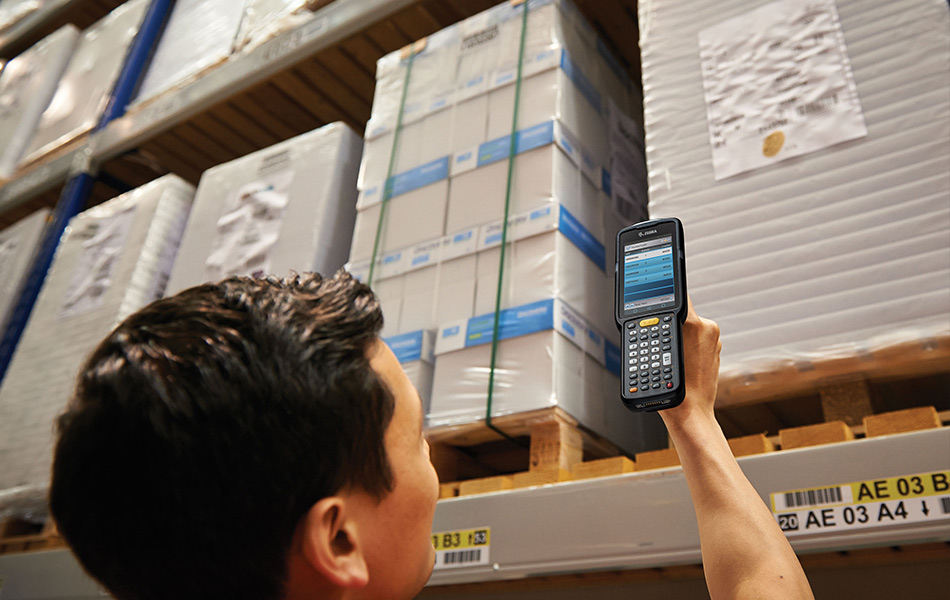 A warehouse operative scanning stock with a handheld computer